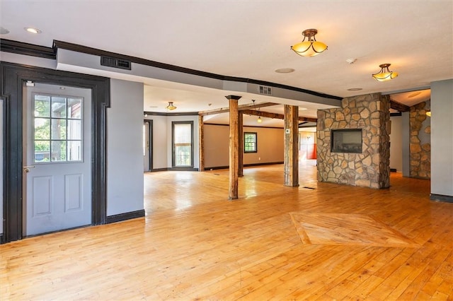 1369 Pittsford Mendon Rd, Mendon, NY 14506 - unfurnished living room featuring crown molding, decorative columns, and light wood-style flooring
