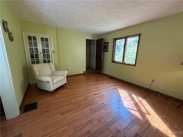237 E Hamilton Ave, Sherrill, NY 13461 - unfurnished room with a textured ceiling, wood finished floors, and french doors