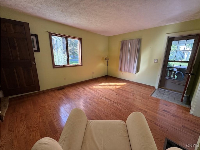 237 E Hamilton Ave, Sherrill, NY 13461 - living room featuring a textured ceiling and wood finished floors