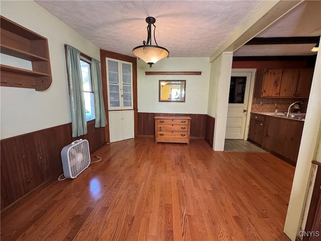 237 E Hamilton Ave, Sherrill, NY 13461 - unfurnished dining area with a textured ceiling, a wainscoted wall, wood finished floors, and wooden walls
