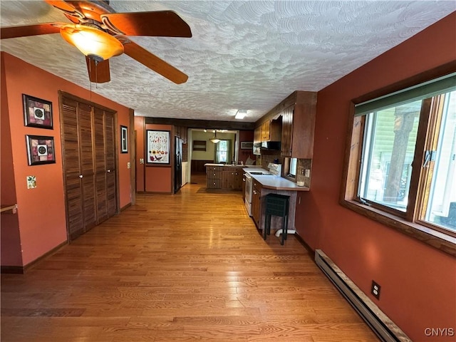 237 E Hamilton Ave, Sherrill, NY 13461 - kitchen featuring white electric range, baseboard heating, light wood-style flooring, a textured ceiling, and ceiling fan