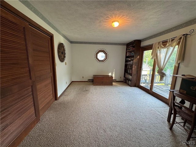 237 E Hamilton Ave, Sherrill, NY 13461 - unfurnished bedroom featuring a textured ceiling, access to exterior, carpet floors, and a closet