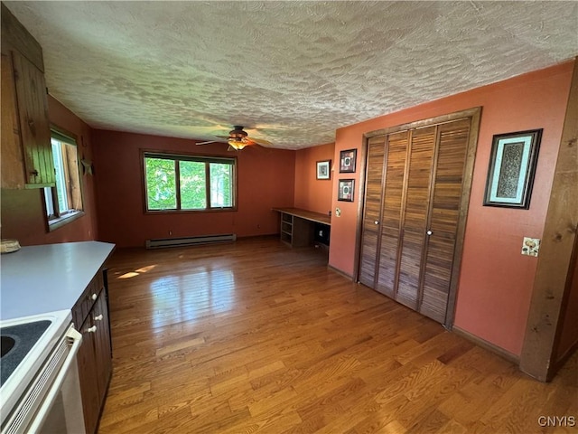 237 E Hamilton Ave, Sherrill, NY 13461 - unfurnished living room with baseboard heating, light wood-style floors, a textured ceiling, and a ceiling fan