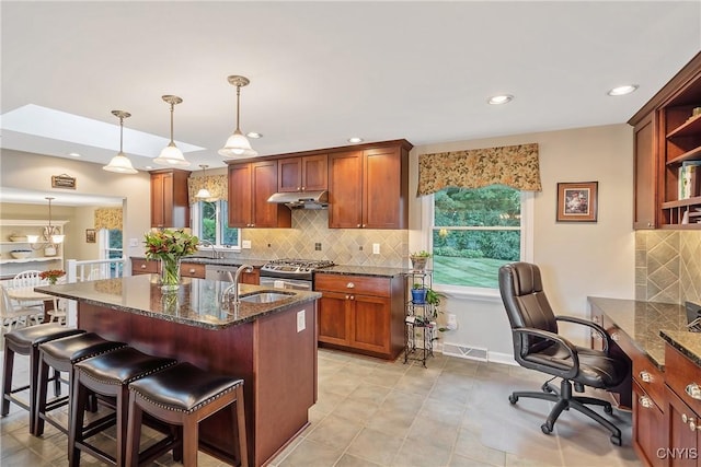 1705 Lancelot Pl, Skaneateles, NY 13152 - kitchen with open shelves, under cabinet range hood, backsplash, dark stone countertops, and recessed lighting