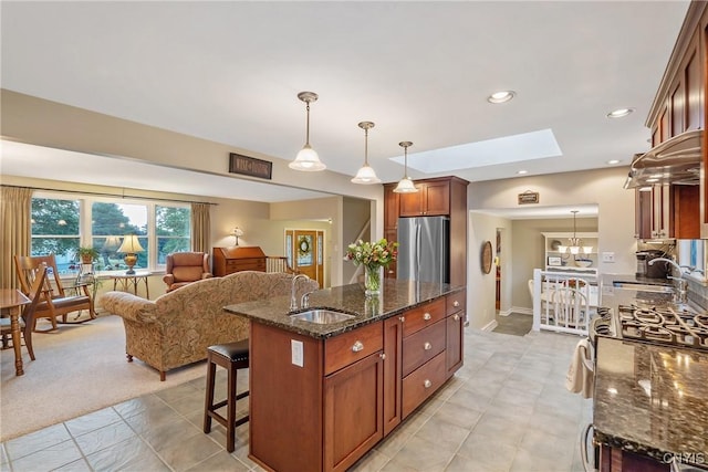 1705 Lancelot Pl, Skaneateles, NY 13152 - kitchen featuring stainless steel appliances, a skylight, open floor plan, an island with sink, and pendant lighting