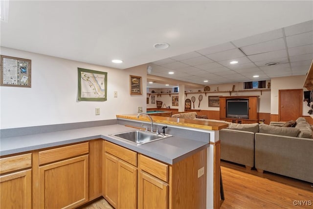 1705 Lancelot Pl, Skaneateles, NY 13152 - kitchen featuring open floor plan, a peninsula, a wainscoted wall, light wood-type flooring, and light countertops