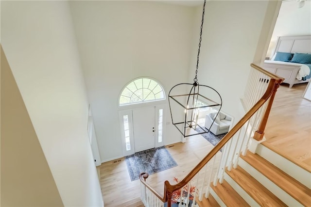 10 Muirfield Ct, Pittsford, NY 14534 - entryway featuring wood finished floors, a high ceiling, a chandelier, and stairway