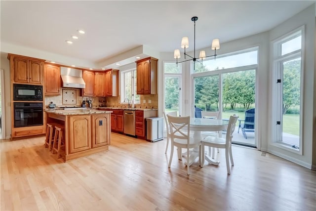 10 Muirfield Ct, Pittsford, NY 14534 - kitchen with black appliances, wall chimney range hood, tasteful backsplash, a chandelier, and recessed lighting