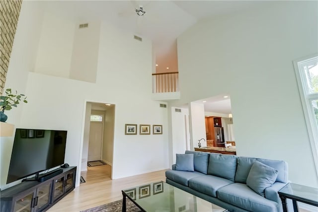 10 Muirfield Ct, Pittsford, NY 14534 - living area featuring a high ceiling, light wood-style floors, and healthy amount of natural light