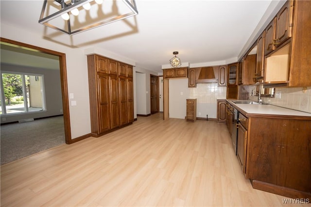 92 Schiller St, Buffalo, NY 14206 - kitchen featuring light wood finished floors, premium range hood, brown cabinetry, and backsplash