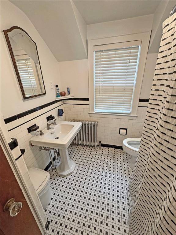 290 Hollywood Ave, Brighton, NY 14618 - bathroom with tile walls, a wainscoted wall, tile patterned floors, and radiator heating unit