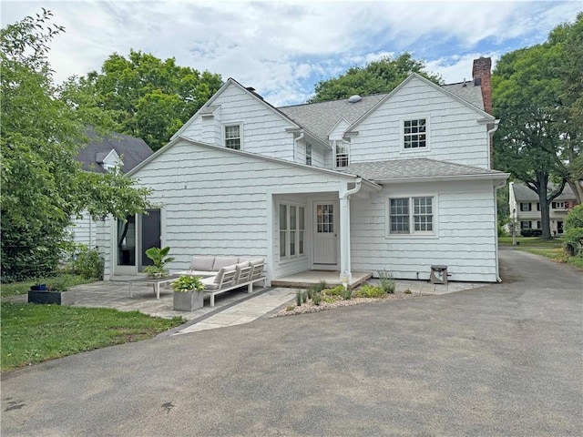 290 Hollywood Ave, Brighton, NY 14618 - rear view of house featuring a chimney, a patio, a shingled roof, and an outdoor hangout area