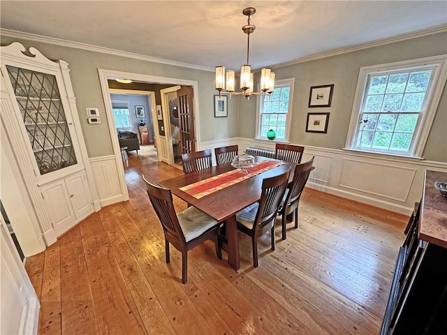 290 Hollywood Ave, Brighton, NY 14618 - dining space with a chandelier, light wood-style flooring, a wainscoted wall, ornamental molding, and a decorative wall