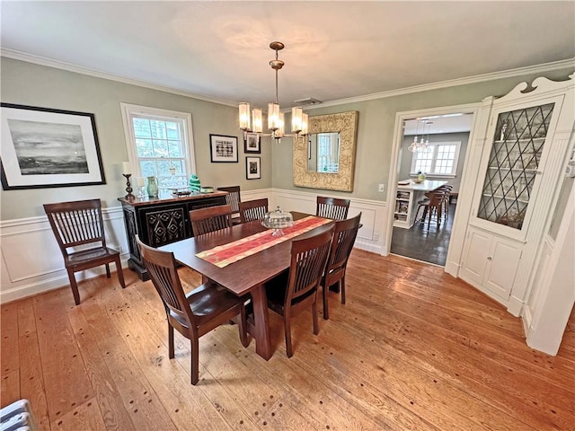 290 Hollywood Ave, Brighton, NY 14618 - dining area featuring a chandelier, light wood-style floors, ornamental molding, healthy amount of natural light, and wainscoting