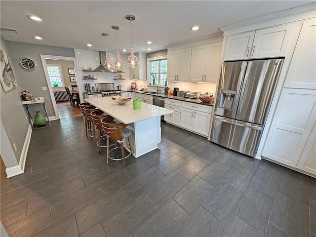 290 Hollywood Ave, Brighton, NY 14618 - kitchen featuring stainless steel appliances, wall chimney range hood, recessed lighting, white cabinets, and a breakfast bar