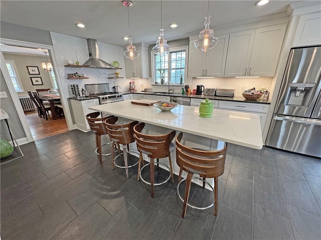 290 Hollywood Ave, Brighton, NY 14618 - kitchen featuring appliances with stainless steel finishes, wall chimney range hood, a kitchen breakfast bar, backsplash, and white cabinets