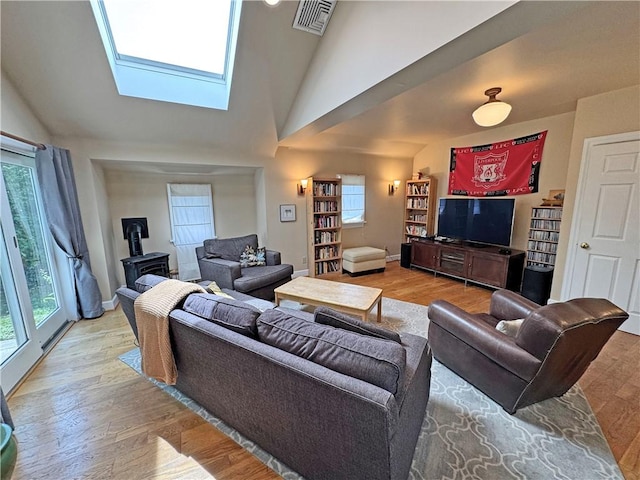 290 Hollywood Ave, Brighton, NY 14618 - living room featuring a wood stove, healthy amount of natural light, wood finished floors, and vaulted ceiling
