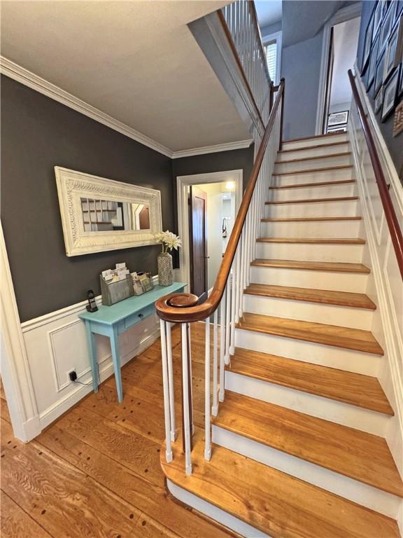 290 Hollywood Ave, Brighton, NY 14618 - staircase featuring wood-type flooring, crown molding, and wainscoting