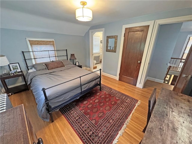 290 Hollywood Ave, Brighton, NY 14618 - bedroom featuring wood finished floors, vaulted ceiling, multiple windows, and ensuite bathroom
