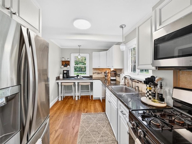 245 Worthington Rd, Irondequoit, NY 14622 - kitchen featuring stainless steel appliances, white cabinetry, tasteful backsplash, healthy amount of natural light, and crown molding