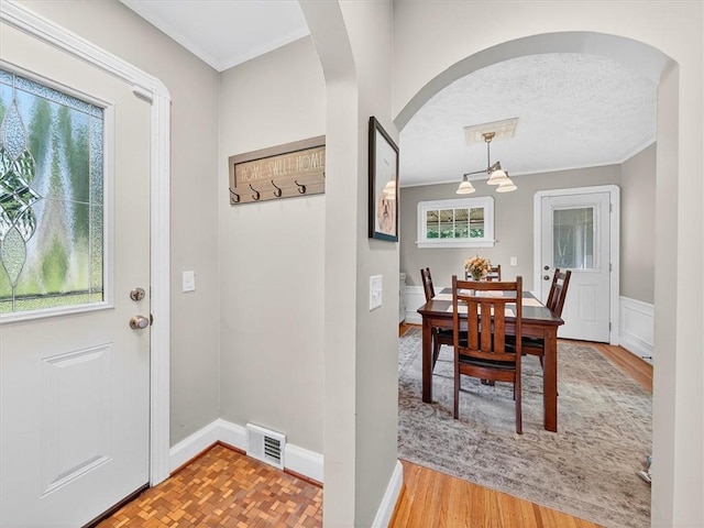 245 Worthington Rd, Irondequoit, NY 14622 - entryway featuring arched walkways, crown molding, wood finished floors, and a textured ceiling
