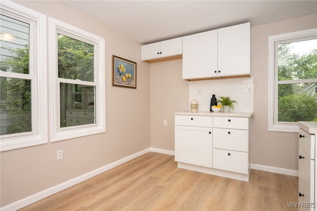 827 Tifft St, Buffalo, NY 14220 - kitchen featuring light wood finished floors, white cabinets, light countertops, and decorative backsplash
