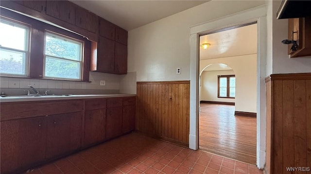 1890 Linwood Ave, Niagara Falls, NY 14305 - kitchen with a wainscoted wall, wood walls, light countertops, and arched walkways