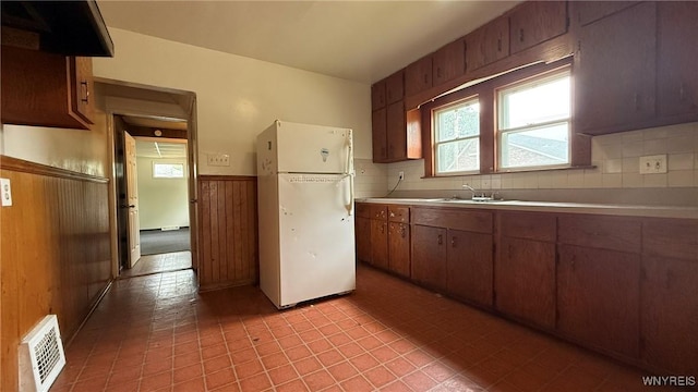 1890 Linwood Ave, Niagara Falls, NY 14305 - kitchen with freestanding refrigerator, wooden walls, light countertops, a wainscoted wall, and light tile patterned floors