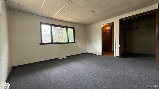 1890 Linwood Ave, Niagara Falls, NY 14305 - unfurnished bedroom featuring a drop ceiling, a walk in closet, and dark carpet