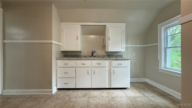 1890 Linwood Ave, Niagara Falls, NY 14305 - kitchen with plenty of natural light, white cabinets, vaulted ceiling, light tile patterned floors, and light stone counters