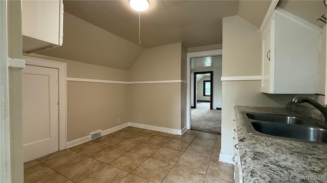 1890 Linwood Ave, Niagara Falls, NY 14305 - kitchen with white cabinets, light tile patterned flooring, lofted ceiling, and light stone countertops