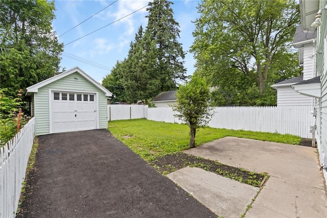 2079 Clifford Ave, Rochester, NY 14609 - fenced backyard featuring a garage, asphalt driveway, and an outbuilding
