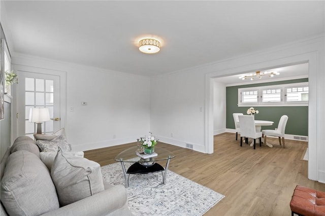 2079 Clifford Ave, Rochester, NY 14609 - living room with a chandelier, crown molding, and light wood finished floors