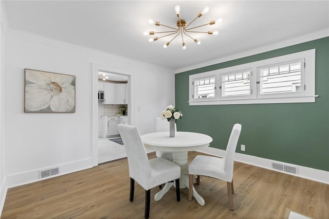 2079 Clifford Ave, Rochester, NY 14609 - dining area with a chandelier, ornamental molding, and light wood finished floors