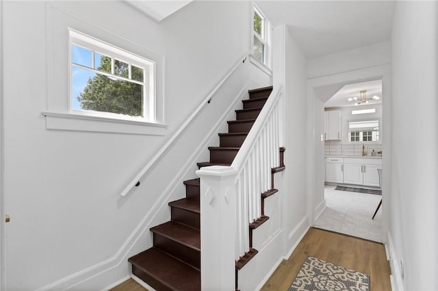 2079 Clifford Ave, Rochester, NY 14609 - stairway with plenty of natural light, wood finished floors, and a chandelier