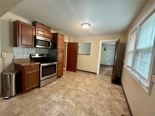 211 Pharis St, Syracuse, NY 13204 - kitchen featuring stainless steel appliances, stone finish floors, backsplash, dark countertops, and brown cabinets