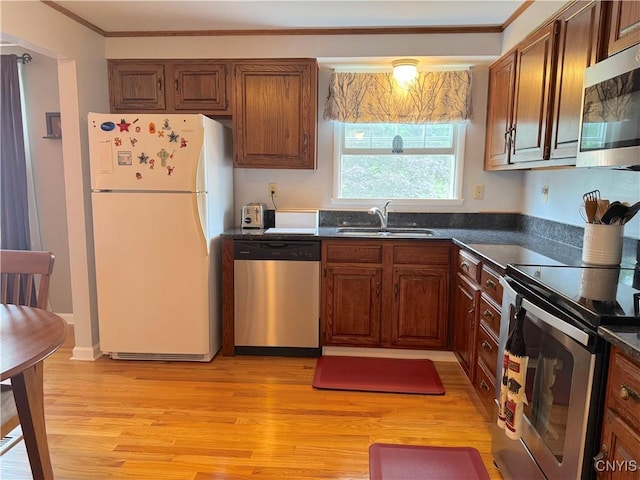 8467 Torchwood Ln, Cicero, NY 13039 - kitchen with stainless steel appliances, dark countertops, light wood-style floors, and ornamental molding