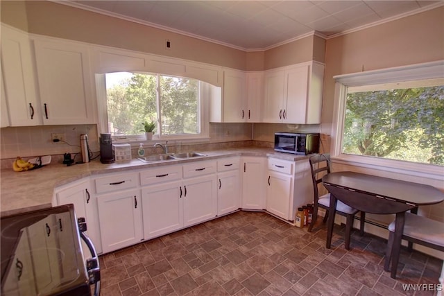 6716 Main St, Cherry Creek, NY 14723 - kitchen featuring stainless steel microwave, stove, light countertops, white cabinetry, and ornamental molding
