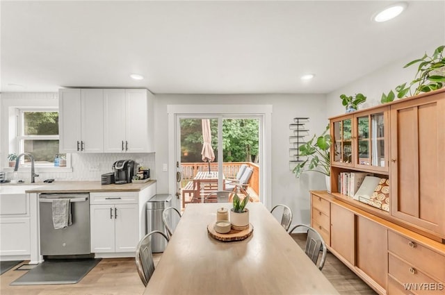 7052 Waring Cir, Evans, NY 14047 - kitchen featuring dishwasher, light countertops, tasteful backsplash, light wood-type flooring, and white cabinets