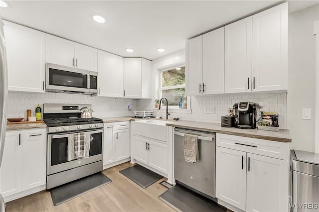 7052 Waring Cir, Evans, NY 14047 - kitchen featuring appliances with stainless steel finishes, light wood-style floors, light countertops, white cabinets, and recessed lighting