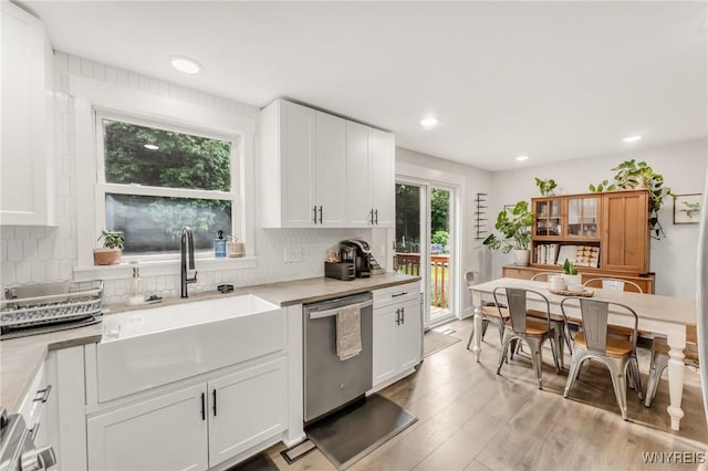 7052 Waring Cir, Evans, NY 14047 - kitchen with dishwasher, light countertops, white cabinets, decorative backsplash, and light wood-style floors