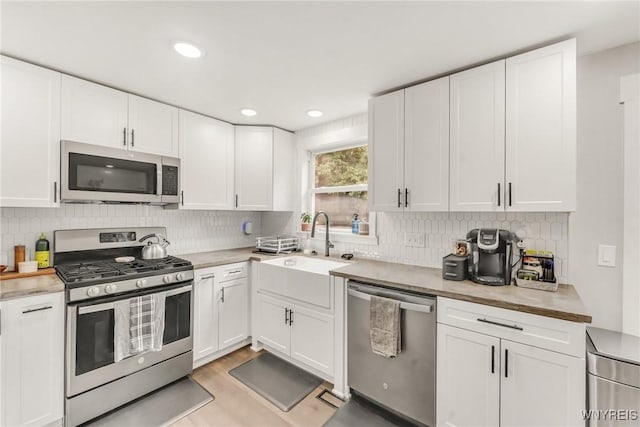 7052 Waring Cir, Evans, NY 14047 - kitchen with appliances with stainless steel finishes, white cabinetry, light countertops, tasteful backsplash, and recessed lighting
