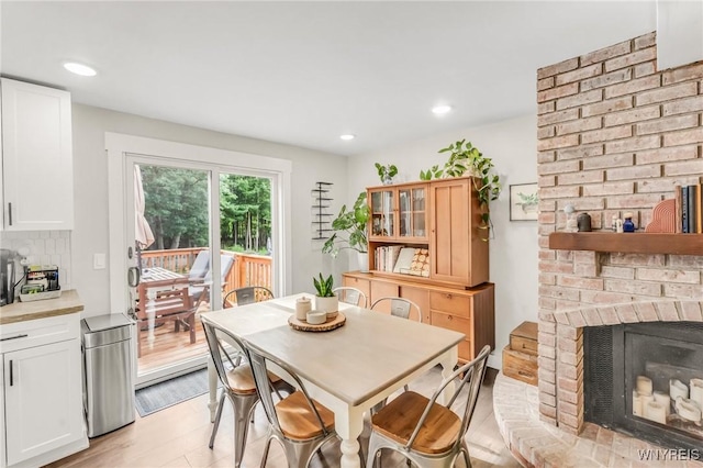 7052 Waring Cir, Evans, NY 14047 - dining area with a brick fireplace, light wood-style flooring, and recessed lighting