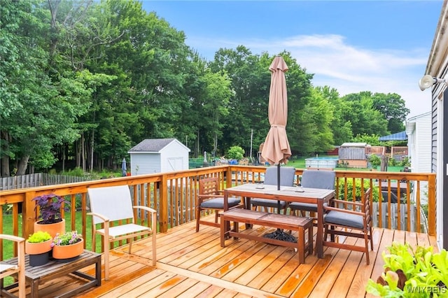 7052 Waring Cir, Evans, NY 14047 - wooden terrace featuring a storage shed, outdoor dining space, and view of scattered trees