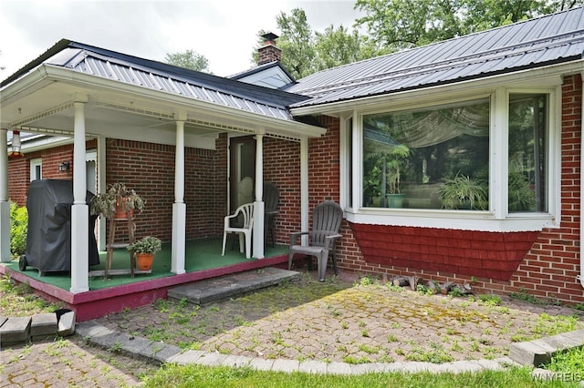 3461 Orchard Park Rd, Orchard Park, NY 14127 - doorway to property featuring brick siding, a metal roof, and a chimney