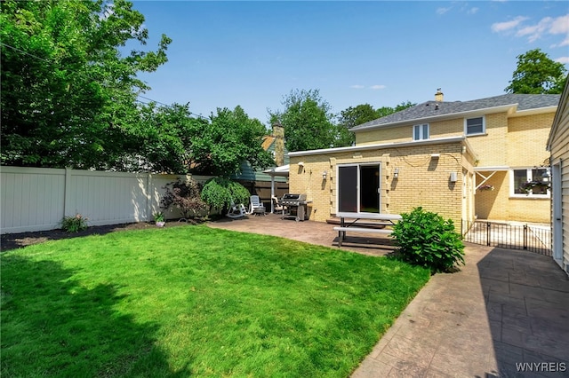 66 Devonshire Rd, Tonawanda, NY 14223 - back of house featuring a patio, a fenced backyard, brick siding, and a chimney
