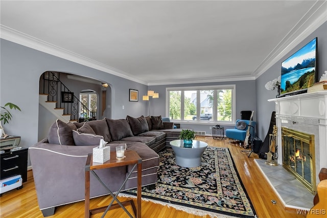 66 Devonshire Rd, Tonawanda, NY 14223 - living area featuring arched walkways, wood finished floors, ornamental molding, a tile fireplace, and stairway