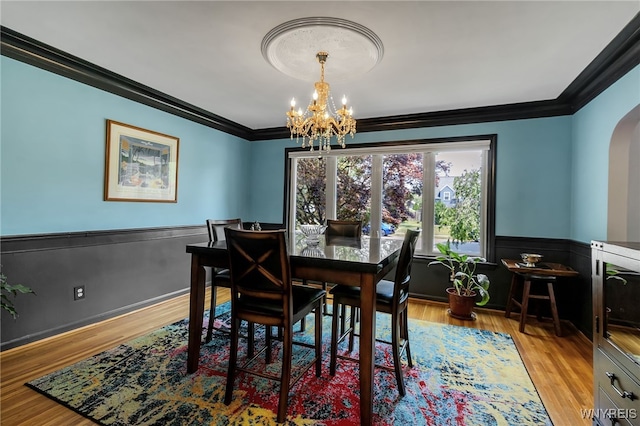 66 Devonshire Rd, Tonawanda, NY 14223 - dining space with crown molding, wainscoting, a chandelier, arched walkways, and light wood-style flooring