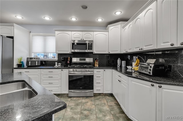 66 Devonshire Rd, Tonawanda, NY 14223 - kitchen featuring stainless steel appliances, white cabinets, tasteful backsplash, dark stone countertops, and recessed lighting