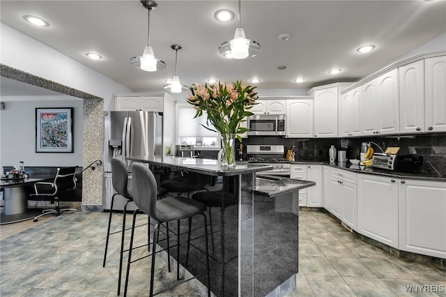 66 Devonshire Rd, Tonawanda, NY 14223 - kitchen with stainless steel appliances, a kitchen island, a breakfast bar, tasteful backsplash, and white cabinetry